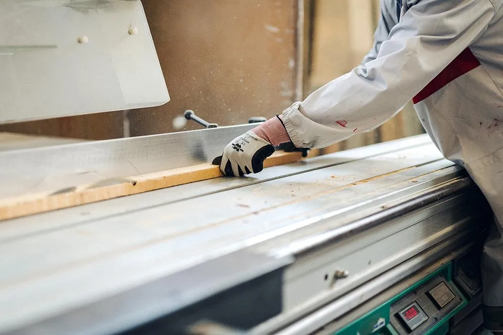 Lavorazione di una tavola di legno a macchina in bottega